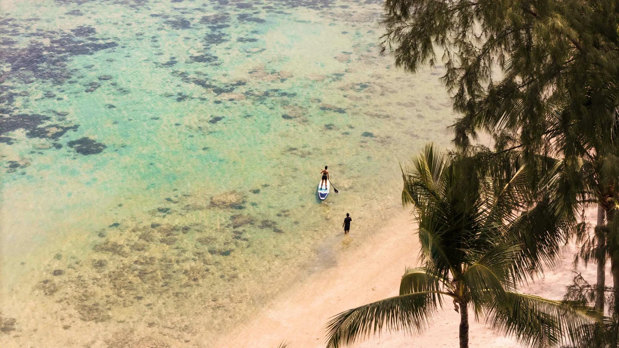 Aerial view of tropical Phuket beach with clear turquoise water.